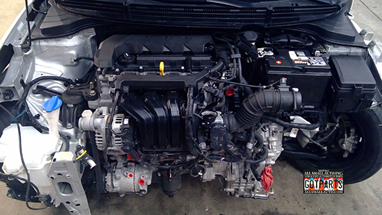 A used Kia engine and surrounding powertrain components, clean and complete, from a salvage vehicle, showcasing the quality OEM Kia parts available for reliable and affordable repairs.